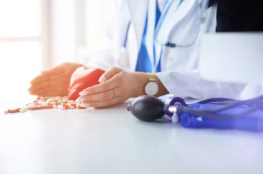 Masada kırmızı kalbi ve steteskopu olan kardiyolog.