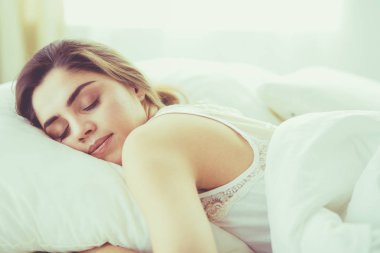 Güzel bir kadın yatağında uzanıyor.