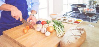 Adam ev mutfağında lezzetli ve sağlıklı yemekler hazırlıyor.