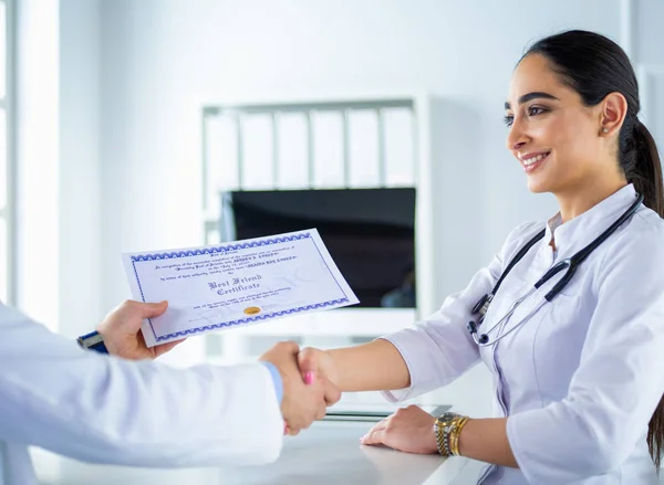 El médico da la mano a un paciente aislado sobre fondo blanco — Foto de Stock