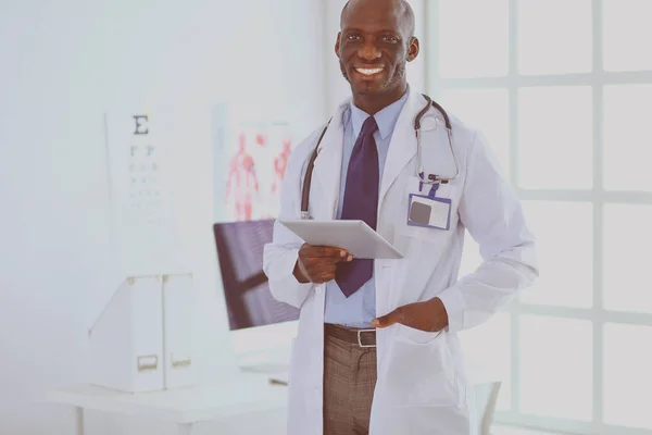 Trabajador médico negro masculino con tableta de pie en el hospital — Foto de Stock