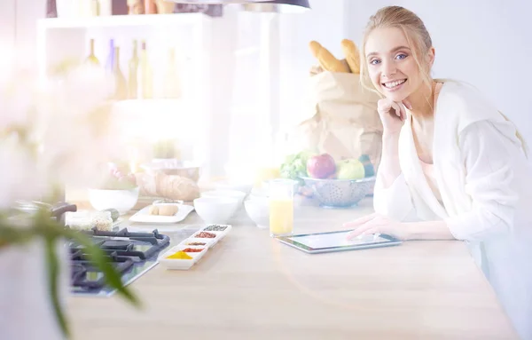 Hermosa joven usando una tableta digital en la cocina —  Fotos de Stock