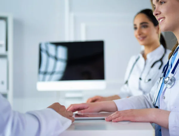 Ärzteteam sitzt und diskutiert am Tisch — Stockfoto