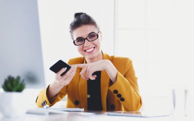 ofis telefon laptop ile oturuyor ve iş kadını