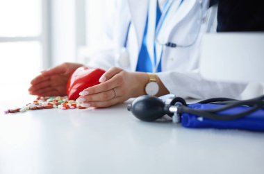 Masada kırmızı kalbi ve steteskopu olan kardiyolog.