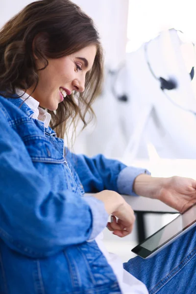 Imagen de una joven confiada sentada en el escritorio — Foto de Stock