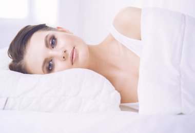 Genç ve güzel bir kadın yatakta yatıyor..