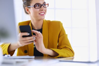 ofis telefon laptop ile oturuyor ve iş kadını