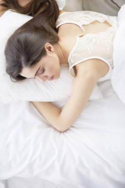 Güzel bir kadın yatağında uzanıyor.