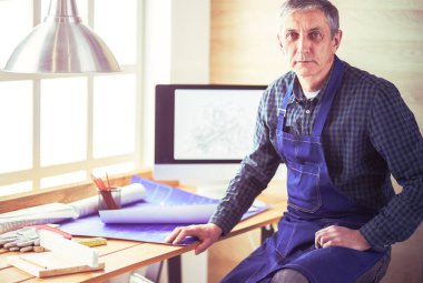 Ofisteki çizim masasında çalışan mimar