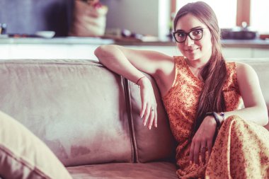 Kanepede oturan gülümseyen kadın portresi. Günlük tarz kapalı çekim.