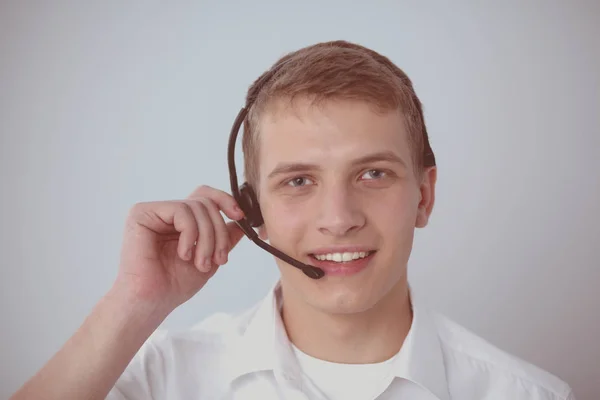 Portret van de jonge man die lacht zittend op een grijze achtergrond. Portret van jonge man — Stockfoto