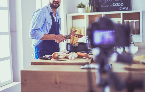 Mann hält Papiertüte voller Lebensmittel auf dem Küchenhintergrund. Shopping und gesundes Ernährungskonzept — Stockfoto