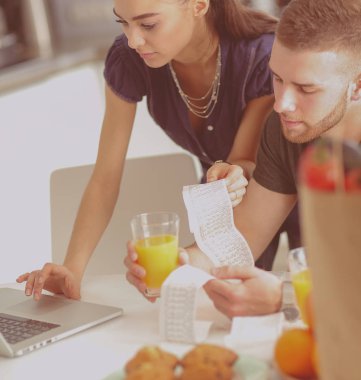 Çift evde mutfak içinde laptop ile onların fatura ödeme