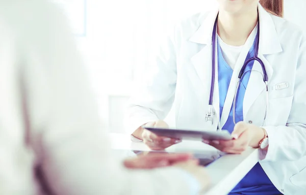 Médico femenino usando tableta en el vestíbulo del hospital, sonriendo —  Fotos de Stock