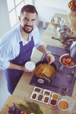 Adam ev mutfağında lezzetli ve sağlıklı yemekler hazırlıyor.