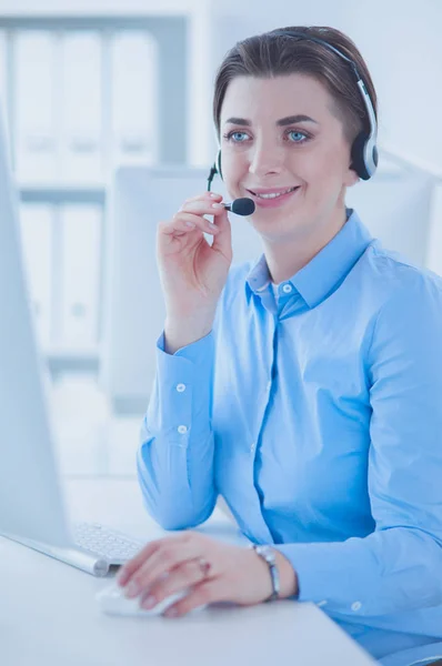 Ernstige mooie jonge vrouw die werkt als support telefoon operator met headset in het kantoor — Stockfoto