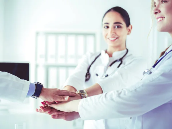 Artsen en verpleegkundigen in een medisch team stapelen handen — Stockfoto