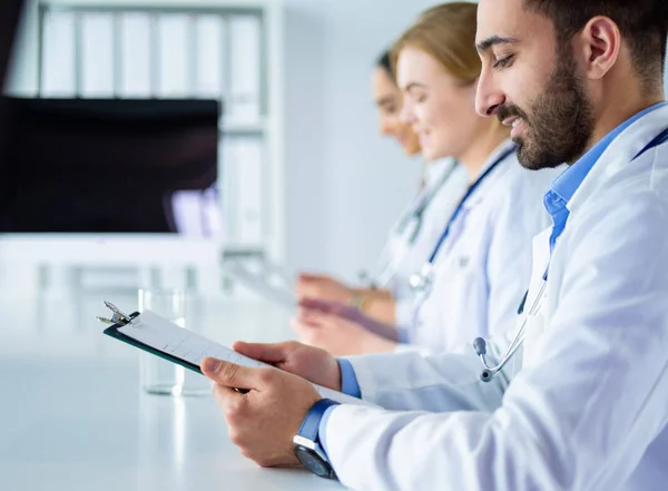 Ärzteteam sitzt und diskutiert am Tisch — Stockfoto