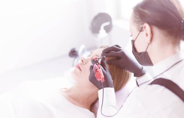 Güzellik salonunda kaş makyajı yapılan genç bir kadın.