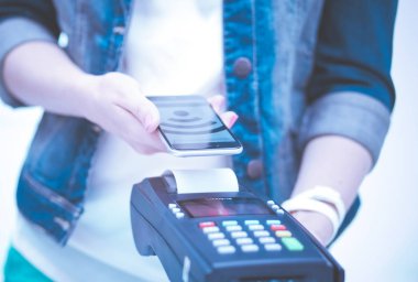 Müşteri ile smartphone Nfc teknolojisi kullanılarak dükkanda ödüyor. NFC teknolojisi. Müşteri ödeme