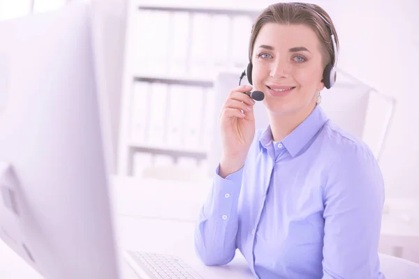 Ernstige mooie jonge vrouw die werkt als support telefoon operator met headset in het kantoor — Stockfoto