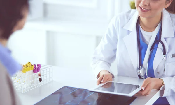 Kvinnlig läkare använder Tablet PC i sjukhus lobby, leende — Stockfoto