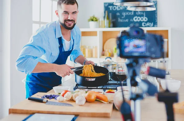 Man met papieren zak vol boodschappen op de keukenachtergrond. Winkelen en gezond voedsel concept — Stockfoto