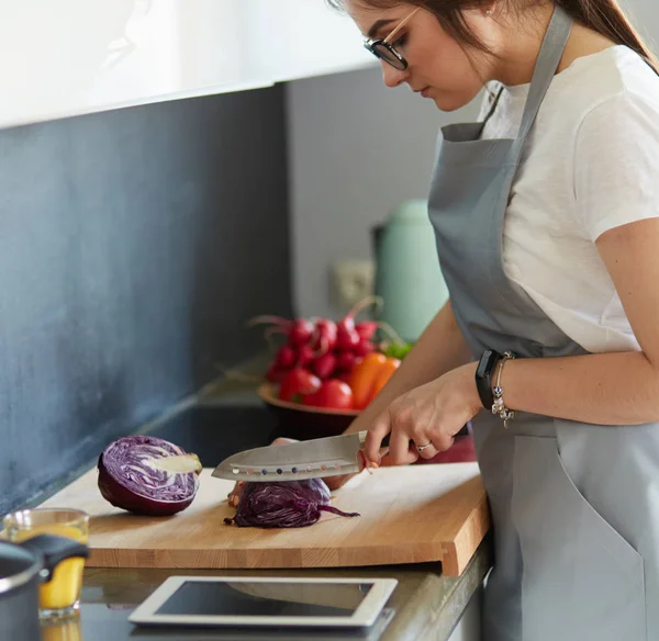 Γυναίκα μαγείρεμα στη νέα κουζίνα κάνοντας υγιεινά τρόφιμα με λαχανικά — Φωτογραφία Αρχείου