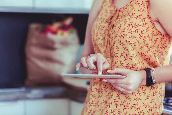 Gyönyörű fiatal nő használ egy digitális tabletta a konyhában — Stock Fotó