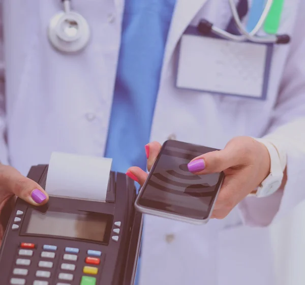 O médico está a segurar o terminal de pagamentos nas mãos. A pagar por cuidados de saúde. Doutor... — Fotografia de Stock