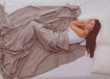 Evdeki yatakta uzanmış güzel esmer