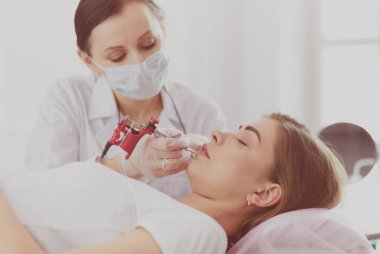 Kırmızı dudaklı genç bir kız kalıcı makyaj, mikro pigmentasyon