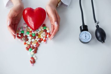 Masada kırmızı kalbi ve steteskopu olan kardiyolog.