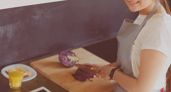Νεαρή γυναίκα που χρησιμοποιεί υπολογιστή tablet για να μαγειρέψει στην κουζίνα της — Φωτογραφία Αρχείου