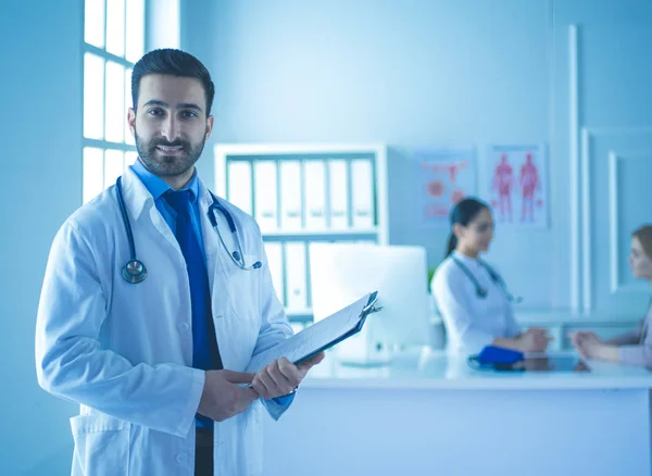 Sonriente médico de pie frente a su equipo y paciente — Foto de Stock