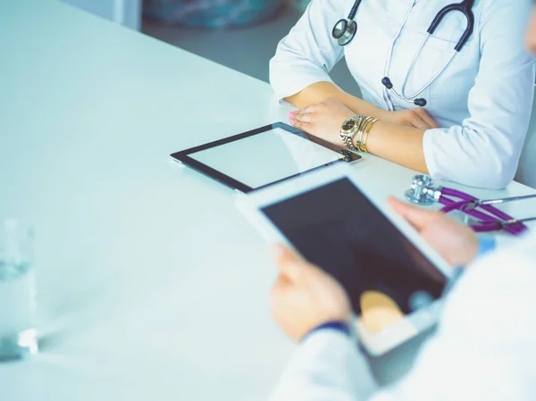 Équipe médicale assise et discutant à table — Photo