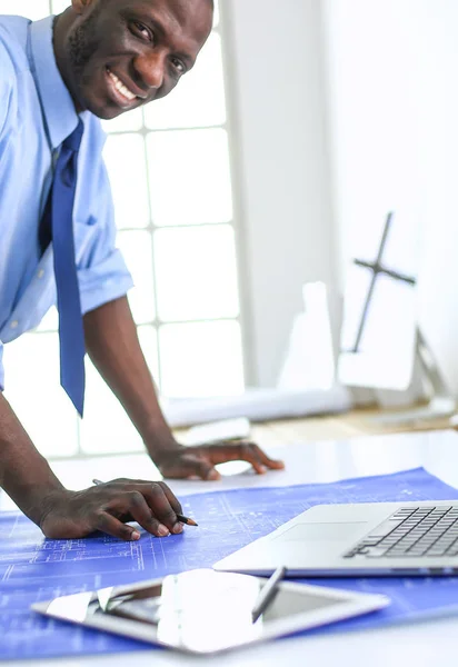 Arquitecto afroamericano trabajando con computadoras y planos en la oficina —  Fotos de Stock