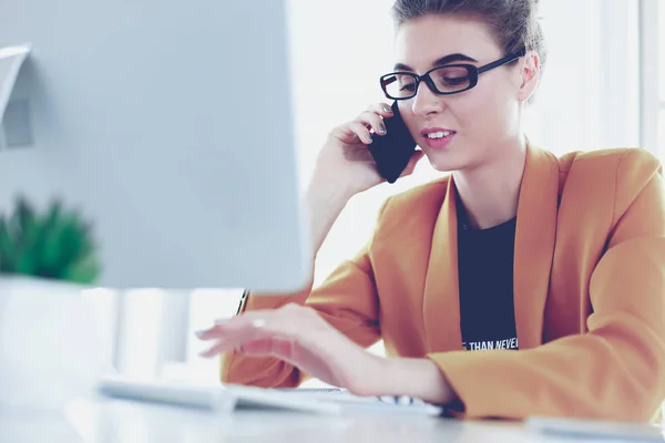 Empresaria concentrándose en el trabajo, usando computadora y celular en la oficina — Foto de Stock