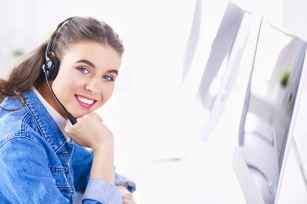 Retrato de mulher de negócios bonita trabalhando em sua mesa com fone de ouvido e laptop — Fotografia de Stock