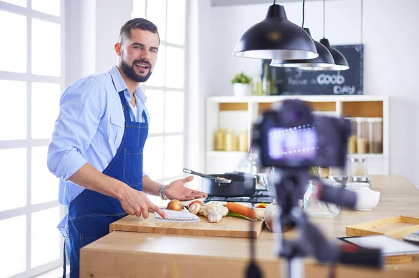 Mann hält Papiertüte voller Lebensmittel auf dem Küchenhintergrund. Shopping und gesundes Ernährungskonzept — Stockfoto