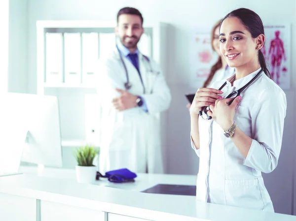 Attractive female doctor in front of medical group — Stock Photo, Image