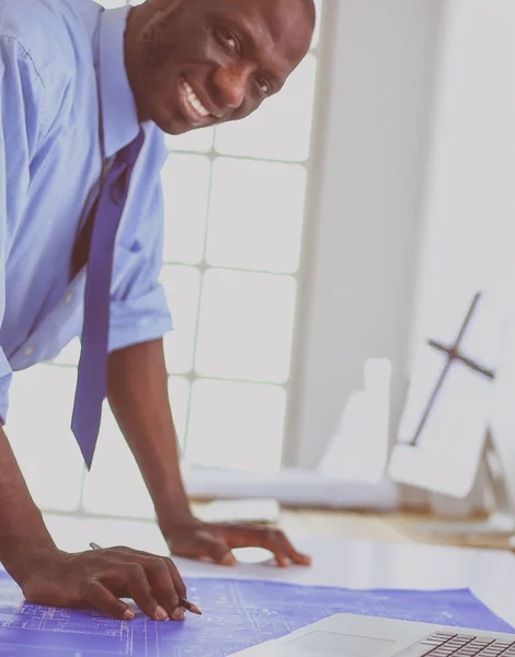 Arquitecto afroamericano trabajando con computadoras y planos en la oficina —  Fotos de Stock