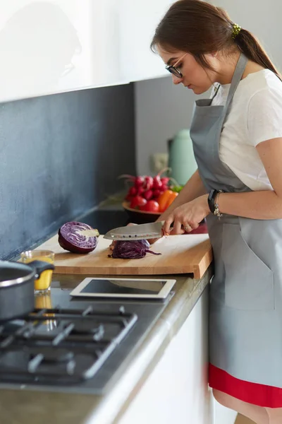 Frau kocht in neuer Küche und bereitet gesunde Lebensmittel mit Gemüse zu — Stockfoto