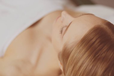 Spa salonunda güzel bir kadının resmi.