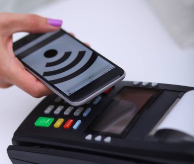 Müşteri ile smartphone Nfc teknolojisi kullanılarak dükkanda ödüyor. NFC teknolojisi. Müşteri ödeme