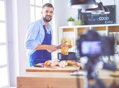 Mutfak arka planında poşet dolusu erzak tutan adam. Alışveriş ve sağlıklı gıda konsepti
