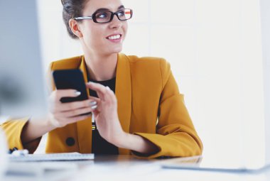 ofis telefon laptop ile oturuyor ve iş kadını