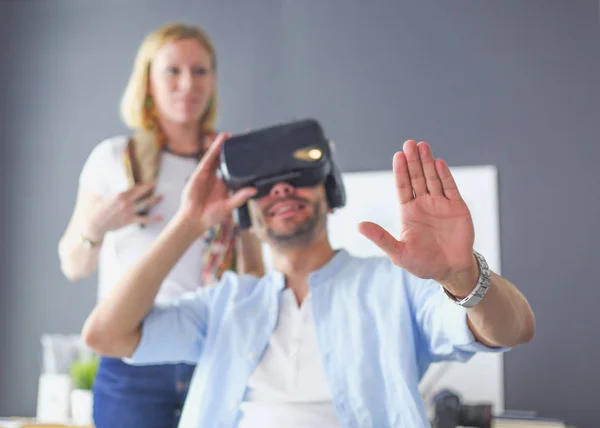 Young male software programmer testing a new app with 3d virtual reality glasses in office.