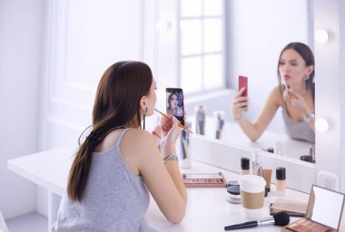 Ayna önünde akıllı telefon ile makyaj eğitimi filme Güzellik blogger